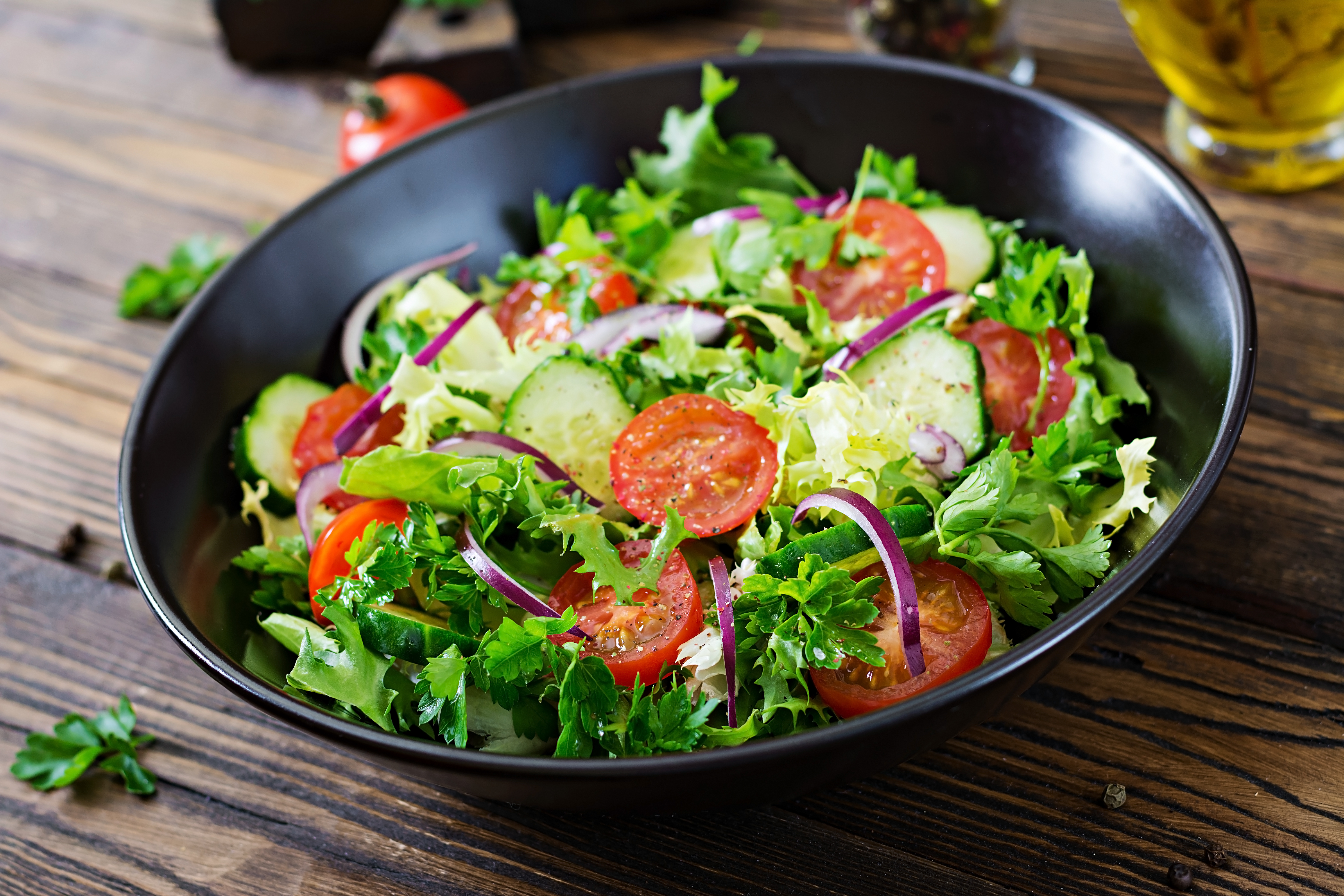 Fresh salad with tomatoes, cucumber, greens, and red onion